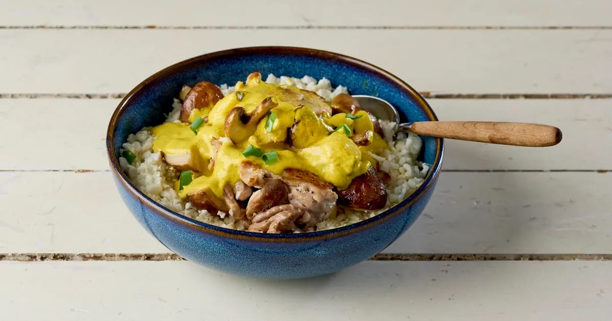 Curry van kippendij en kastanjechampignons met bloemkoolrijst